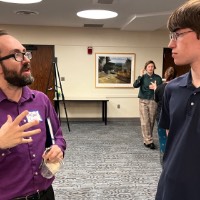 Michael Lynn talks to GVSU student during Capstone Celebration.